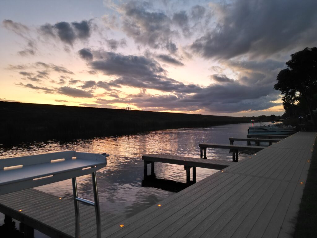 Sunset view of marina with boat slips and fish cleaning station at Buckin' Bass RV Park